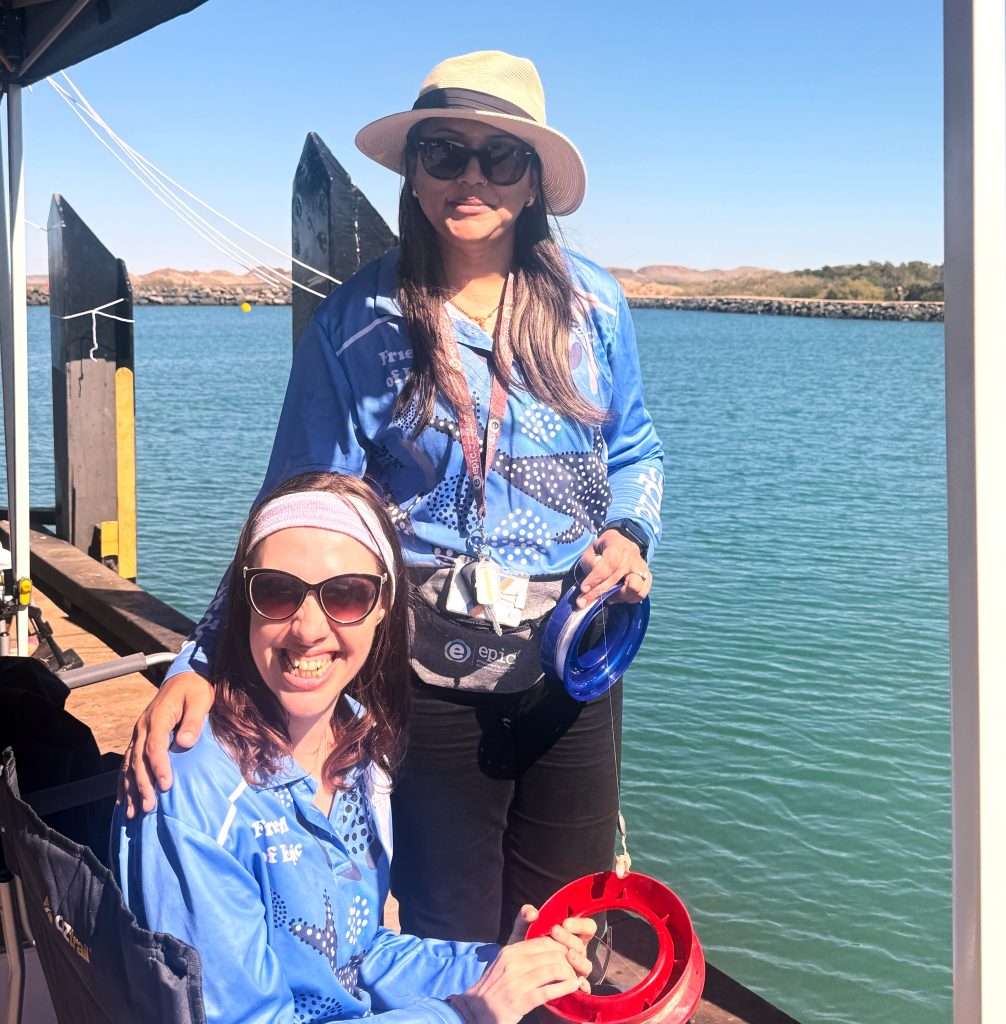 Support worker and client fishing on wharf
